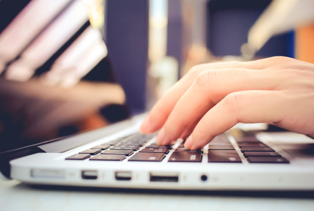 Female Hands Typing On Keyboard Of Laptop